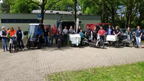 In der Stadt Aachen in einer Art Park stehen einige der Teilnehmer der Aktion "flottes Gewerbe" mit ihren Lastenrädern nebeneinander. Das Cargo PACK ist auch dabei.