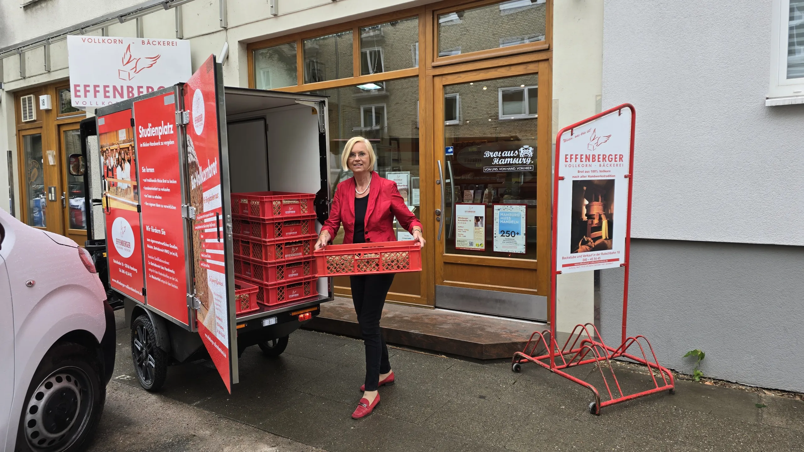 Frau auf einem E-Lastenfahrrad der Bäckerei Effenberger vor einer Filiale, bereit für eine nachhaltige Lieferung.