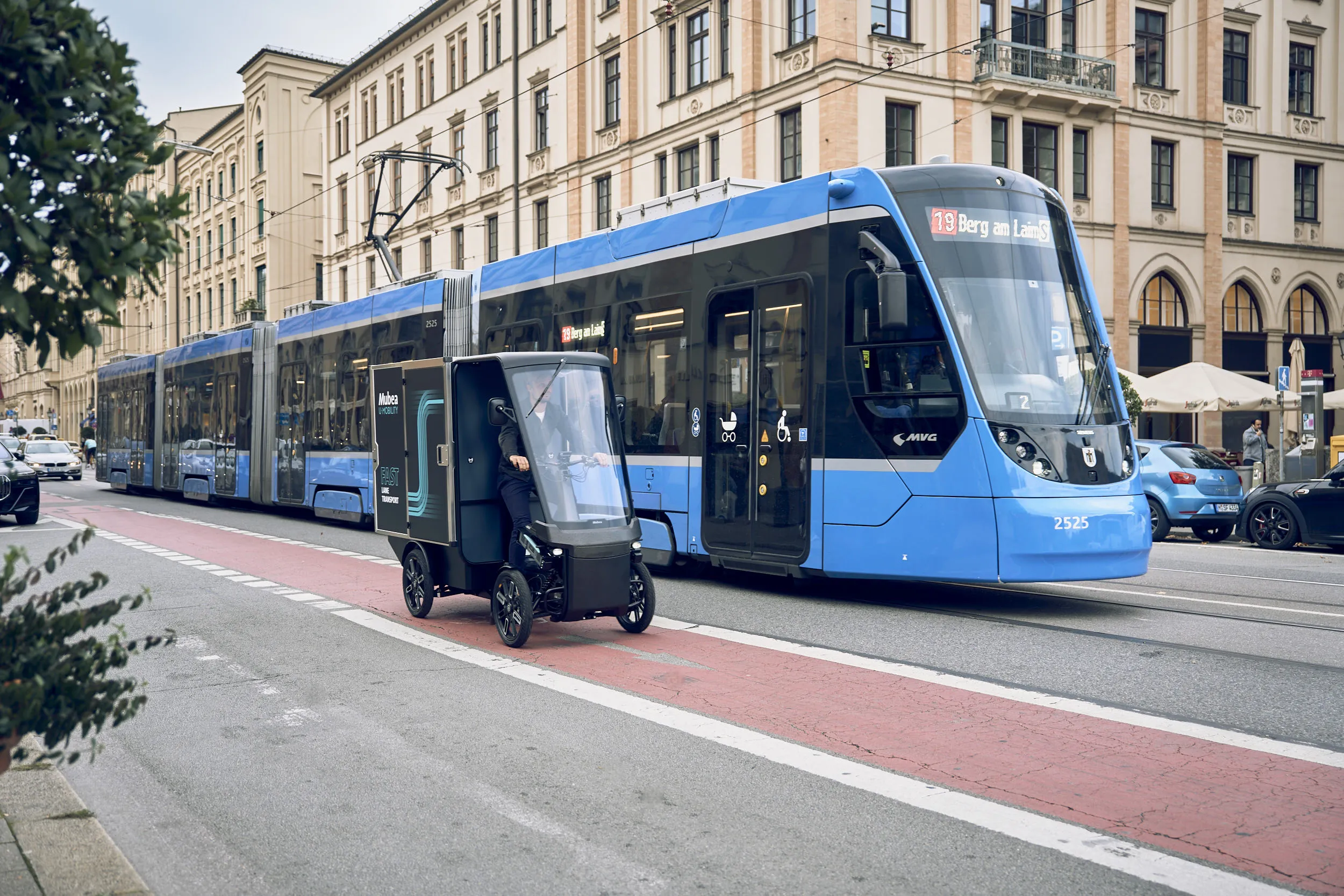 Cargo PACK und Strassenbahn fahren parallel aneinander vorbei
