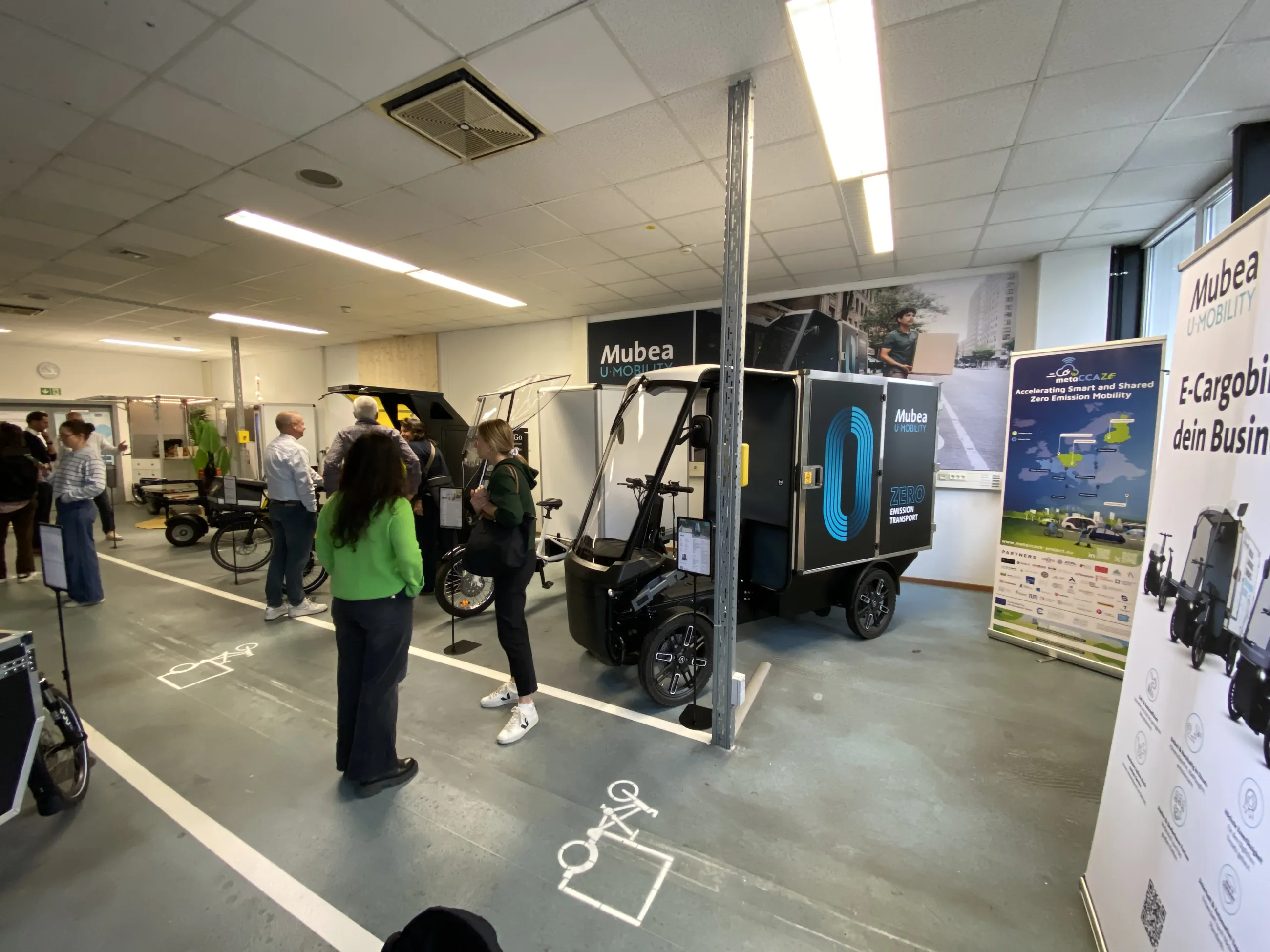 Ausstellung mit Mubea E-Cargobikes und Besuchenden im B2B Lastenrad Zentrum München