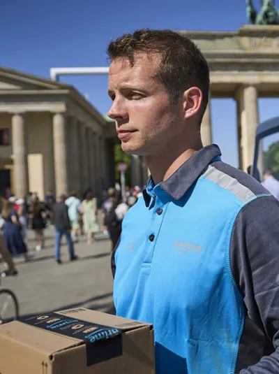 Amazon-Lieferant am Brandenburger Tor mit Cargo PACK ein Paket aus.