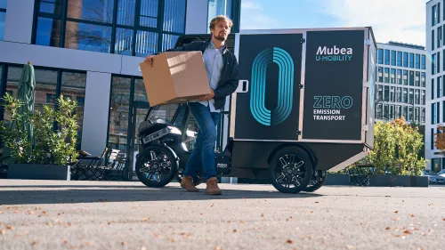 Vor modernen Gewerbegebäuden werden mit dem PACK Pakete geliefert.