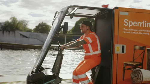 BSR-Mitarbeiter fährt mit dem orangefarbenen Mubea-Cargobike „Sperrling“ zum Sperrmüll-Abholen