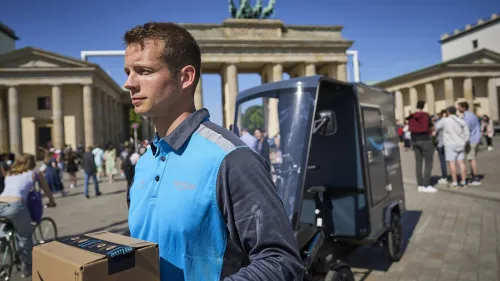 Amazon-Lieferant am Brandenburger Tor mit Cargo PACK ein Paket aus.