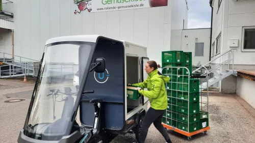 Mitarbeiterin von "Rollende Gemüsekiste" beim Einpacken des Cargo PACKs
