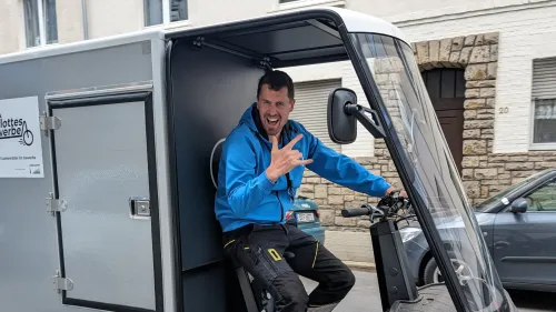 Ein Mitarbeiter der Firma Seilworx fährt mit einem Cargo PACK und zeigt eine Pose in die Kamera. Auf dem Lastenrad steht außerdem "Flottes Gewerbe".