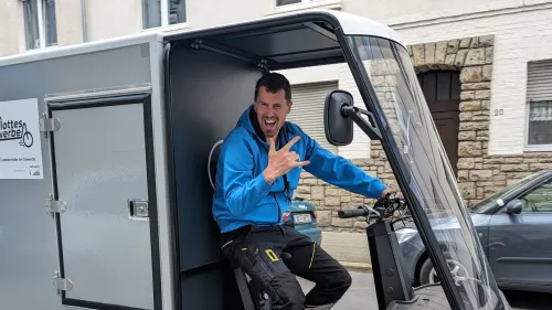 Ein Mitarbeiter der Firma Seilworx fährt mit einem Cargo PACK und zeigt eine Pose in die Kamera. Auf dem Lastenrad steht außerdem "Flottes Gewerbe".