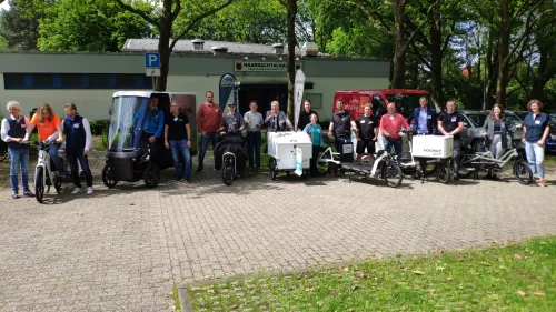 In der Stadt Aachen in einer Art Park stehen einige der Teilnehmer der Aktion "flottes Gewerbe" mit ihren Lastenrädern nebeneinander. Das Cargo PACK ist auch dabei.