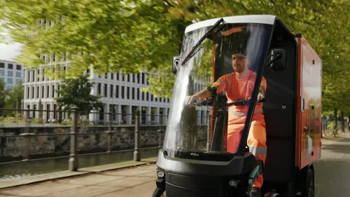 BSR employee rides along the river on the orange Mubea cargo bike ‘Sperrling’