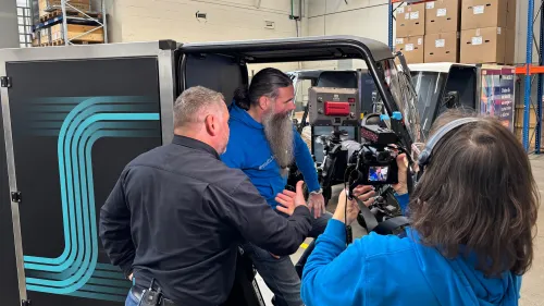 Filmteam interviewt einen Mann im eCargobike in der Mubea U-Mobility Produktion in Attendorn.