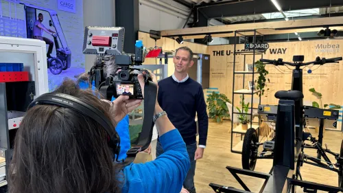 Kamerateam filmt einen Mann zwischen eCargobikes im Mubea U-Mobility Showroom in Attendorn.