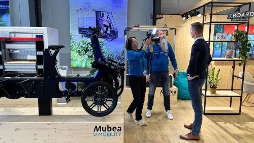 Filmteam interviewt einen Mann im Mubea U-Mobility Showroom neben einem ausgestellten eCargobike.