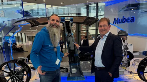 Zwei Männer stehen im Mubea-Showroom vor einem Exponat und unterhalten sich gut gelaunt.