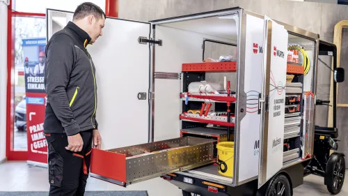 Junger Mann sieht in den Boxaufbau eines Würth E-Cargobikes