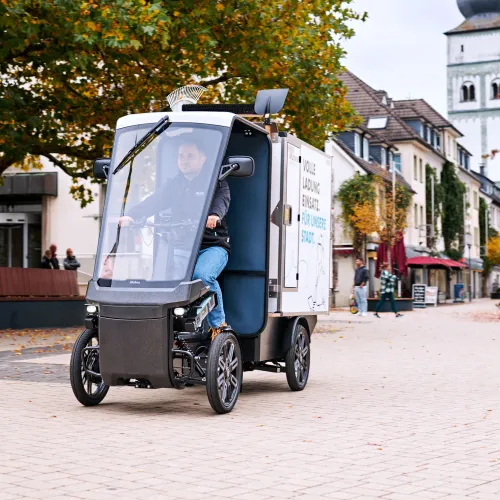 eCargobike rides through an autumnal city.