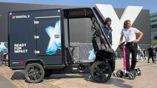 Digital X 2024: Lastenrad und E-Scooter mit Fahrern vor einem Gebäude der Digital X